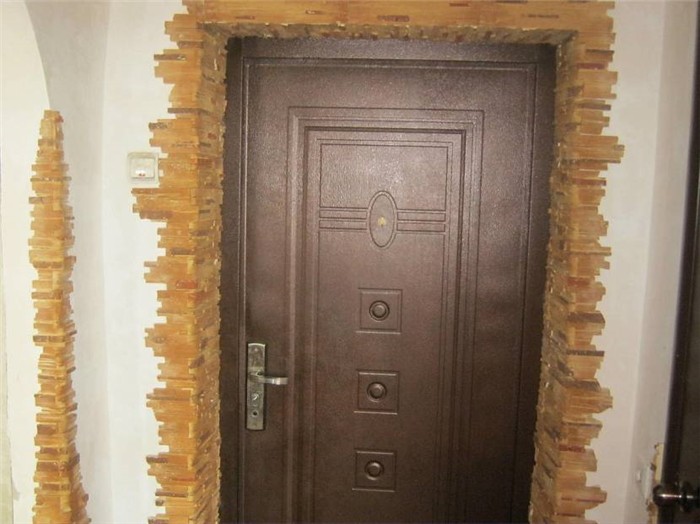 Входная металлическая дверь и откосы из камня
