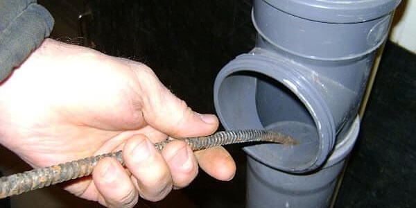 Чистка трубы через ревизию на канализации